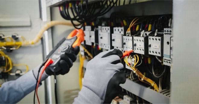 employee checking electrical wiring for damages