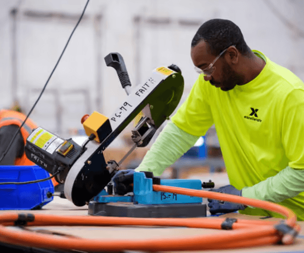 a manufacturing worker safely cutting a wire with