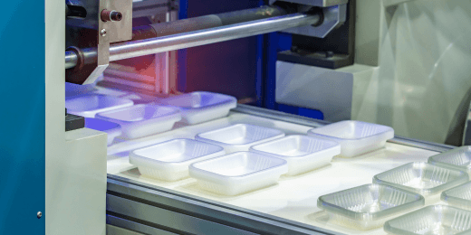 Food containers being packaged in a factory.