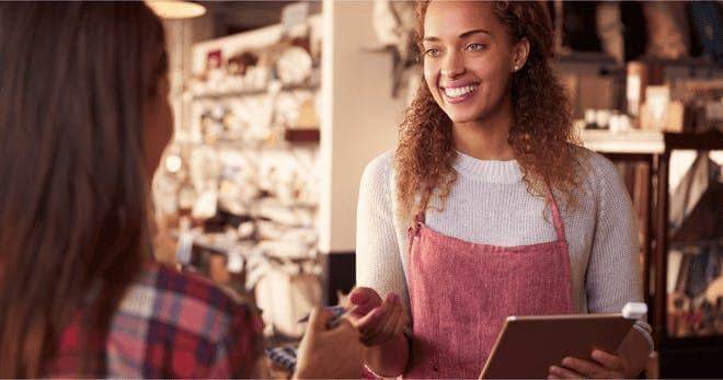 Sales assistant with credit card reader on digital tablet