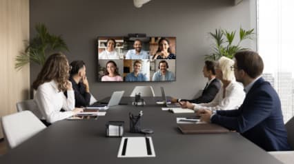 Groupe de collègues en réunion avec des personnes en ligne