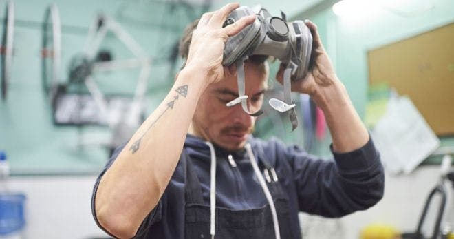 A man putting on a respirator