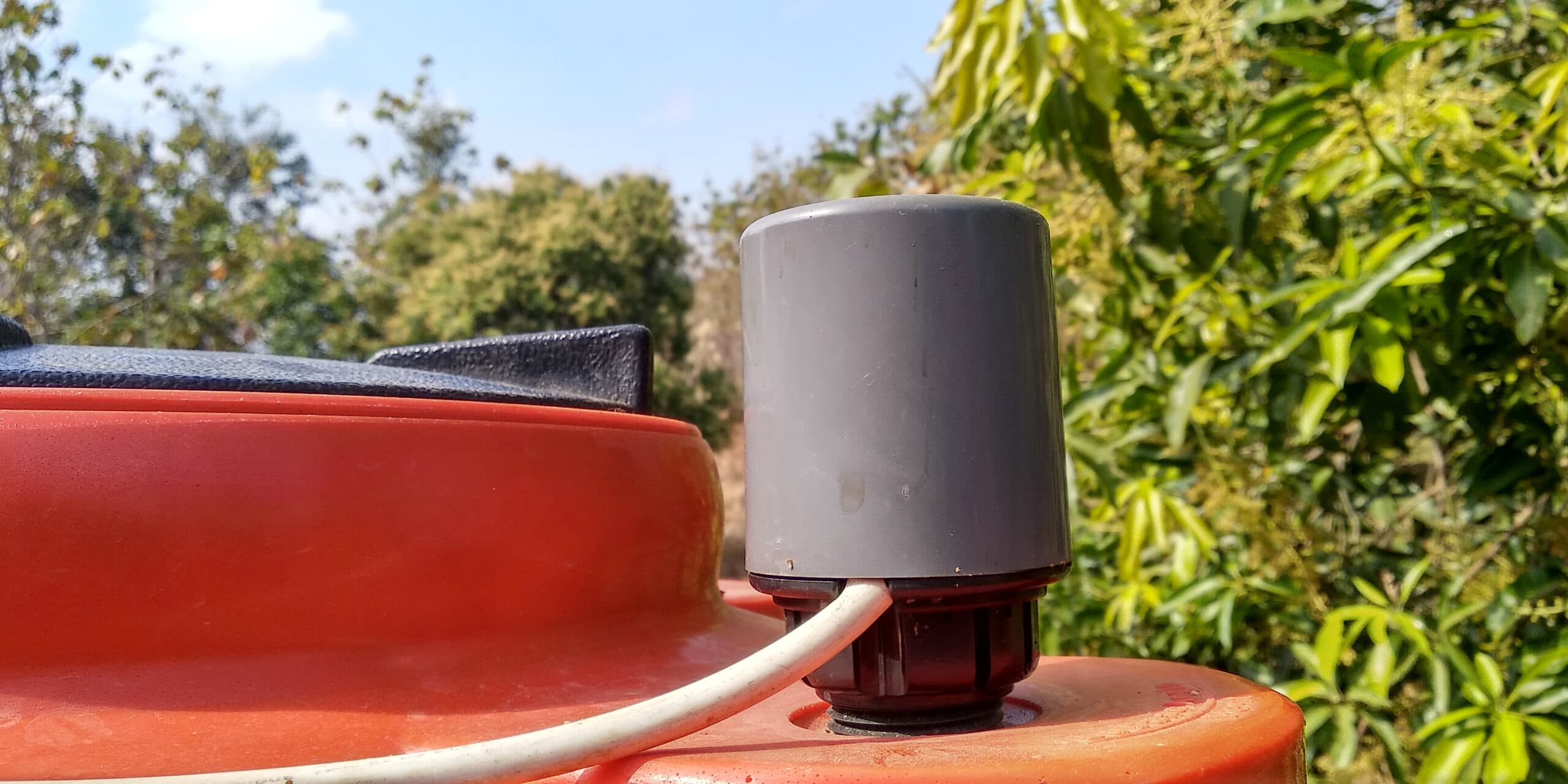 A liquid level sensor mounted on top of a tank.